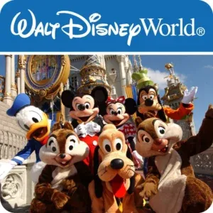 A group photograph of iconic Disney characters posing in front of Cinderella Castle at Magic Kingdom. The lineup includes Mickey Mouse, Minnie Mouse, Donald Duck, Goofy, Pluto, and Chip 'n' Dale. They are positioned on a stone walkway under a clear blue sky, with the golden and blue architectural details of the castle visible in the background.